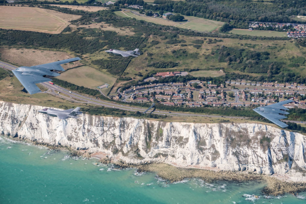 A United States Air Force B2 Spirit, currently deployed to RAF Fairford in Gloucestershire, flies above the English countryside near Dover with two RAF F-35 jets