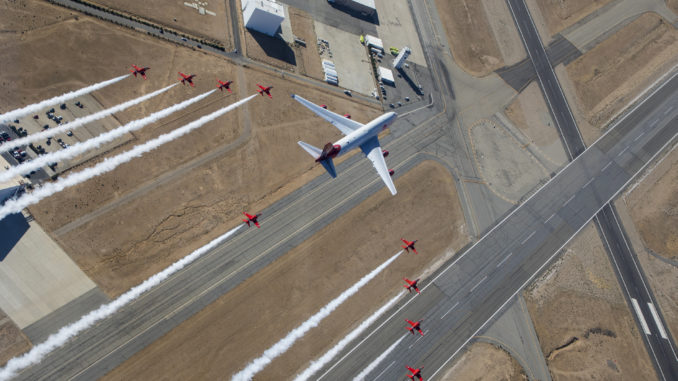 Pictured is the Virgin Orbit 'Cosmic Girl' launch aircraft flying in formation alongside the Red Arrows Hawk jets. (© Crown Copyright 2019)