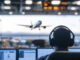 An Air traffic controller monitoring flight operations at airport. scene captures focus and responsibility of ensuring safe takeoffs and landings